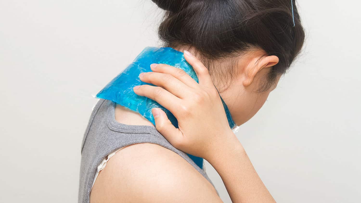 woman putting gel pack on swollen neck