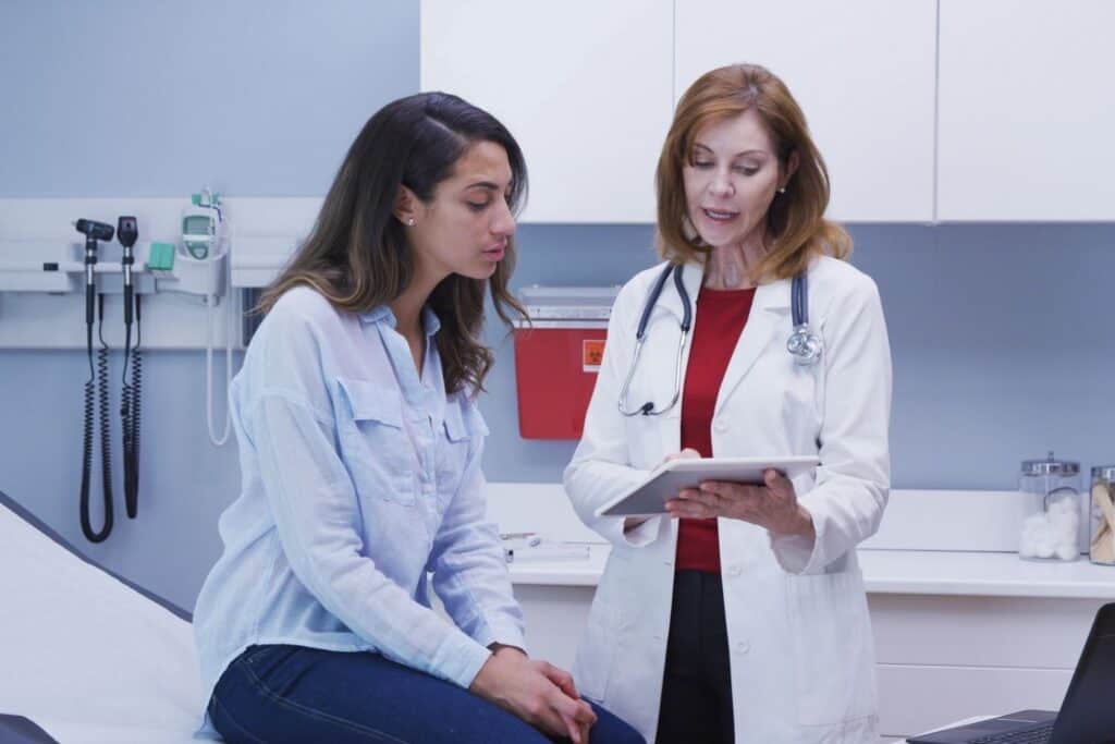 Young woman discussing test results with her physician.