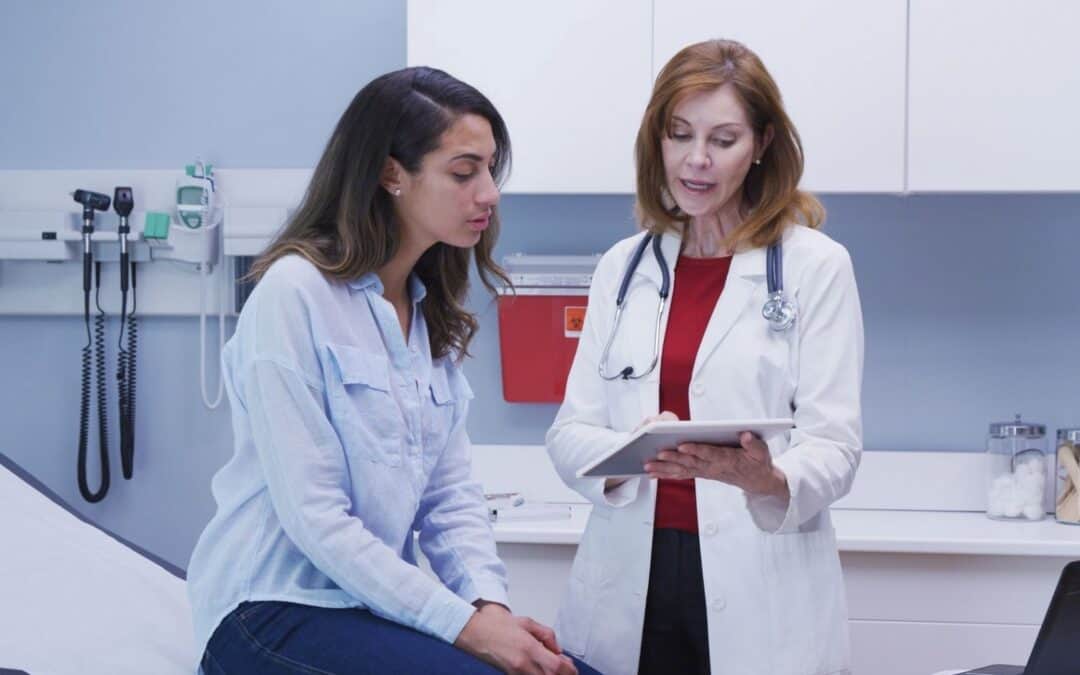 Young woman discussing test results with her physician.